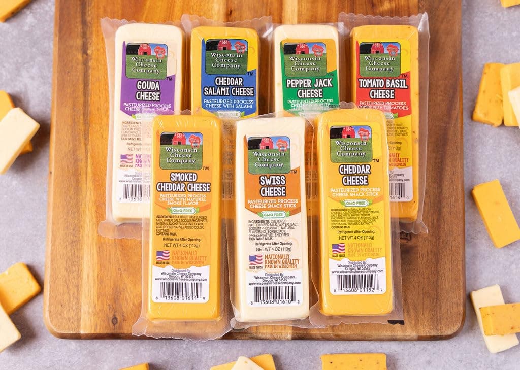 - Wisconsin Cheese Company – 100% Wisconsin Specialty Cheese Block Sampler Gift Pack (7 Blocks) – Cheddar, Pepper Jack, Swiss, Gouda, Salami, Smoked Cheddar & Tomato Basil | Perfect for Parties, Charcuterie Boards, and Holiday Gifts